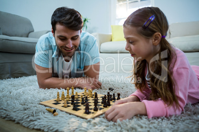 Father and daughter playing chess in the living room
