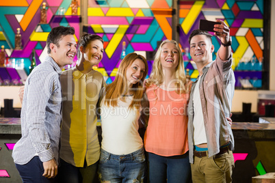 Smiling friends taking a selfie from mobile phone