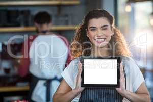 Smiling waitress showing digital tablet at counter in cafÃ?Â©