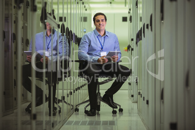 Portrait of technician siting on chair and using digital tablet