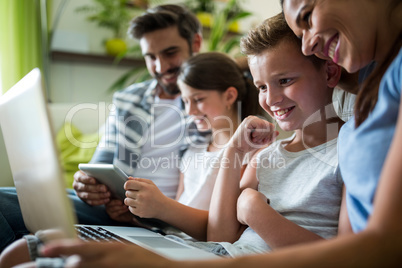 Happy family using laptop and digital tablet in the living room