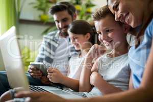 Happy family using laptop and digital tablet in the living room