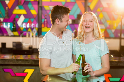 Happy couple toasting a beer bottles