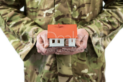 Mid section of soldier holding a model home