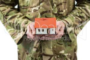 Mid section of soldier holding a model home