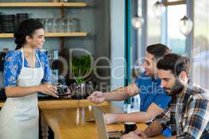 Waitress serving a cup of coffee to customer