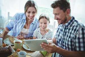 Family using digital tablet while having breakfast