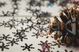 Close-up of pine cone and snowflake on wooden table