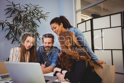 Business people using laptop in meeting room