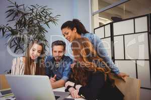 Business people using laptop in meeting room