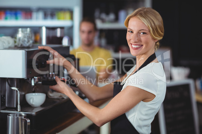 Portrait of smiling waitress making cup of coffee