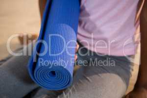 Woman holding exercise mat