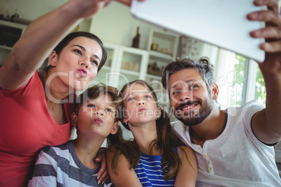 Happy family taking a selfie with digital tablet