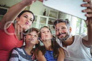 Happy family taking a selfie with digital tablet