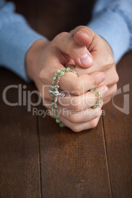 Praying hands of man with a rosary