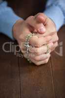 Praying hands of man with a rosary