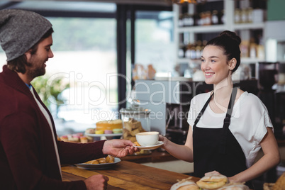 Waitress serving a cup of coffee to customer