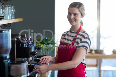 Smiling waitress making cup of coffee in cafÃ?Â©