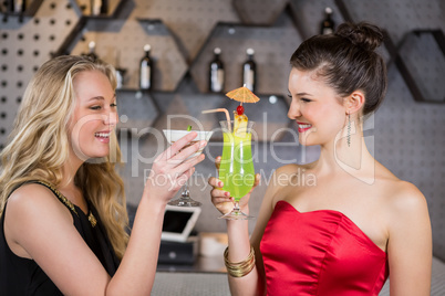 Female friends toasting a glass of cocktail in bar