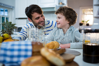 Father and son having breakfast in the kitchen