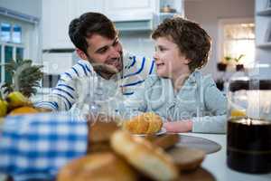 Father and son having breakfast in the kitchen