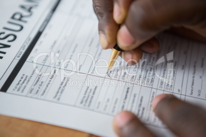Hands of a man signing insurance document