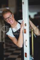 Smiling waitress standing at cafe door