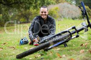 Male cyclist relaxing in park with mountain bike
