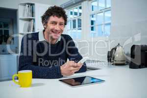 Man holding mobile phone in the kitchen