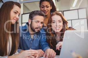 Creative business people using laptop at desk