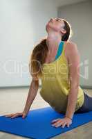 Woman doing cobra pose on exercise mat