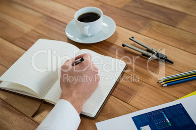 Businessman writing on a diary