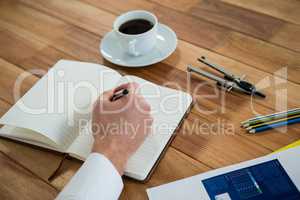 Businessman writing on a diary