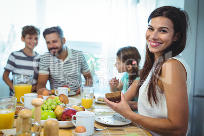 Portrait of happy woman sitting at breakfast table