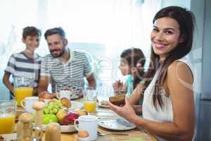 Portrait of happy woman sitting at breakfast table