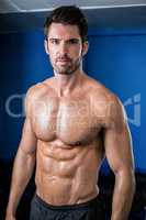 Portrait of shirtless male athlete in gym