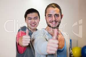 Happy men showing thumbs up