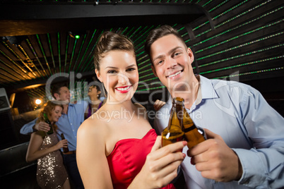 Happy couple toasting a beer bottles