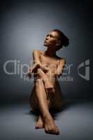 Studio photo of beautiful naked woman sitting