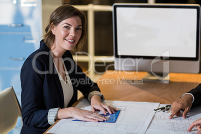 Businesswoman with blueprint in the office