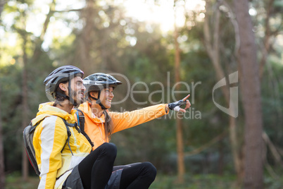 Biker couple sitting and pointing in distance