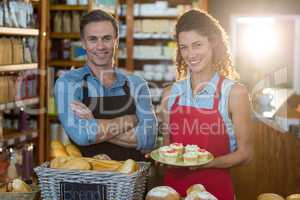 Portrait of smiling staff standing at bakery counter