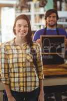 Waiter holding open signboard and standing with customer