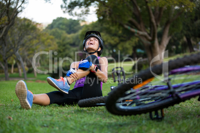 Female cyclist getting injured while falling from mountain bike