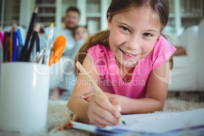 Girl lying on the floor and drawing