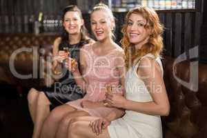 Three female friends having tequila in bar