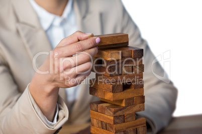 Businesswoman placing wooden block on a tower