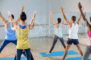 Yoga instructor helping student with a correct pose