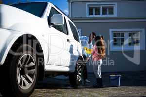 Father and daughter washing car together