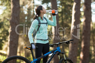 Female biker drinking water